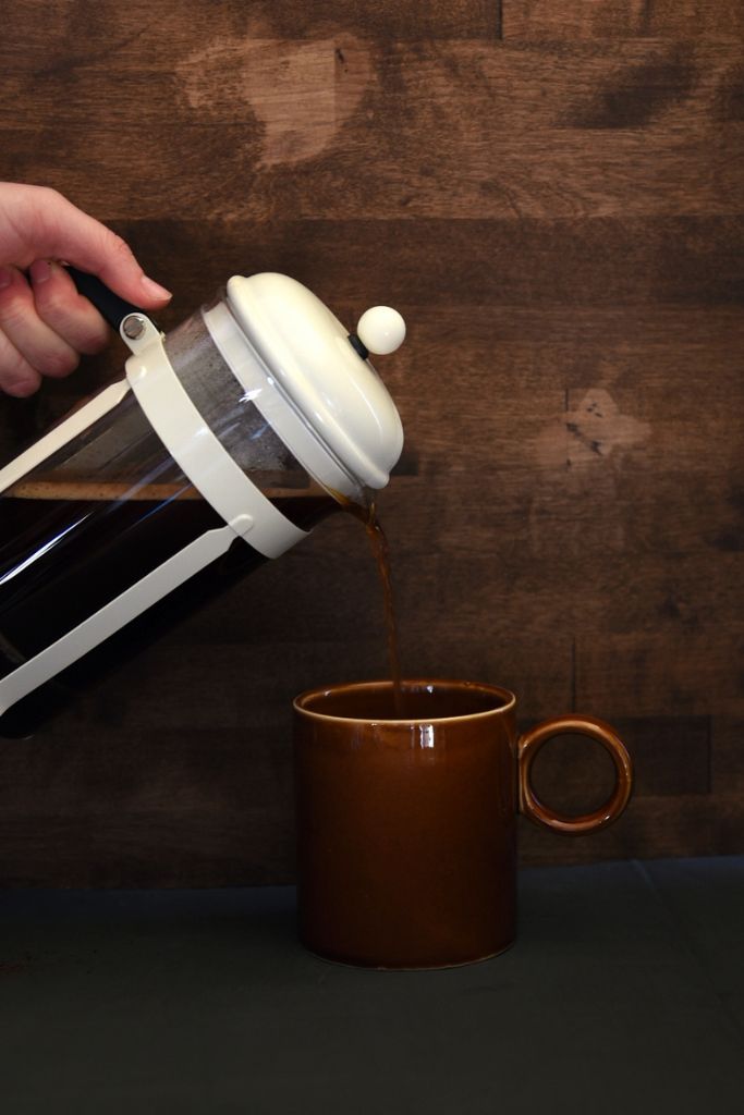 pouring coffee from a french press into a mug