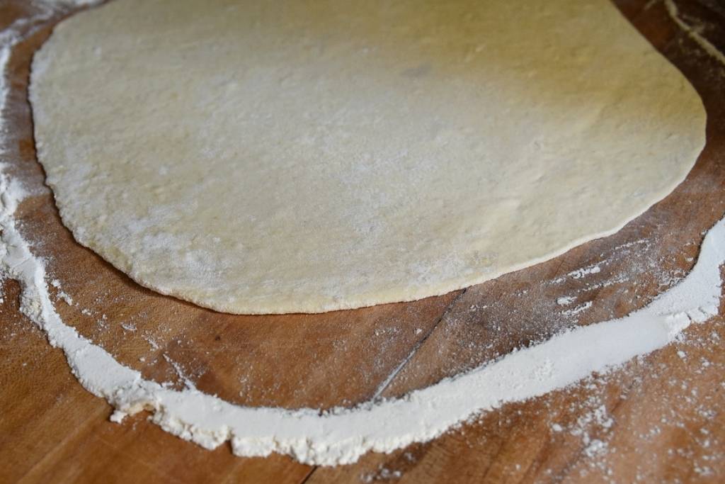 a side view of rolled out pizza crust
