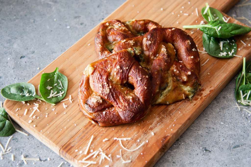 three pretzels on a wooden cutting board