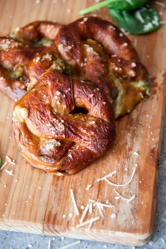three stuffed pretzels on a wooden cutting board