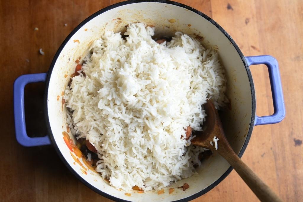 overhead image of the pot with a spoon in it and rice covering the mixture