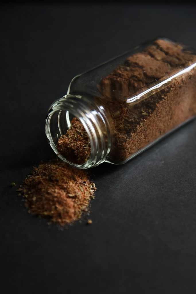 a spice bottle laying on it's side with seasoning spilling out