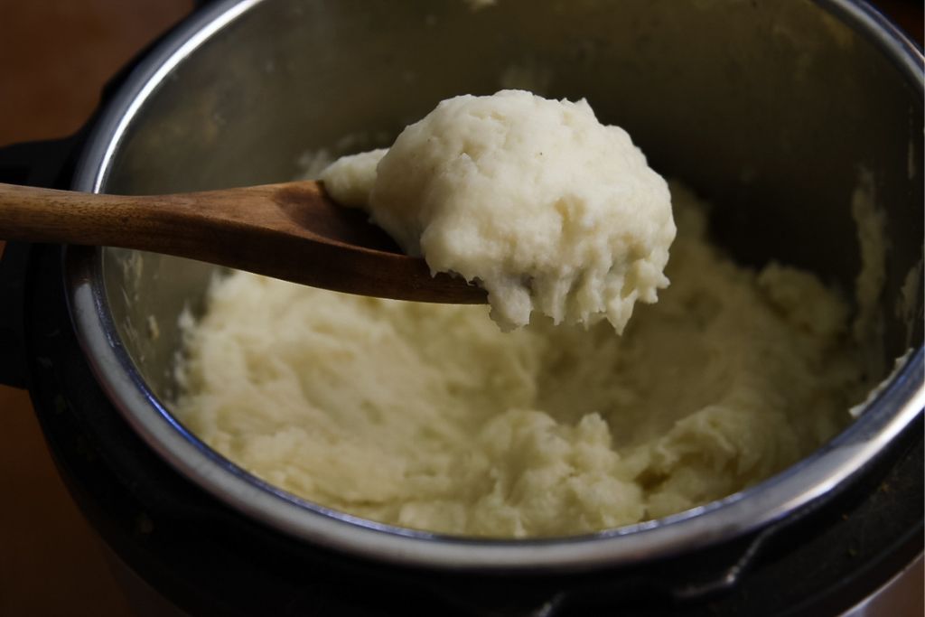 a spoonful of mashed potatoes over an instant pot
