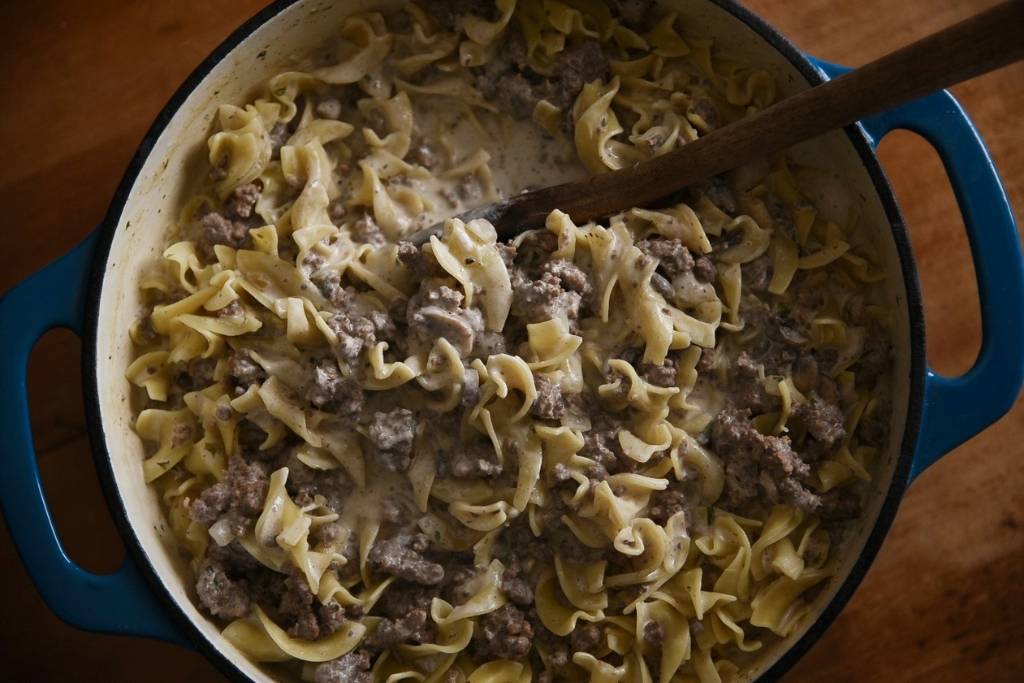 a pot of beef stroganoff with a wooden spoon in it.