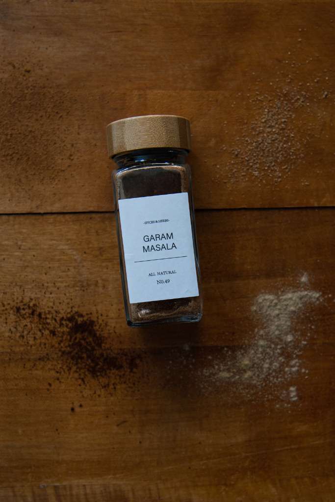 a spice jar laying on a table with spilled spices around it