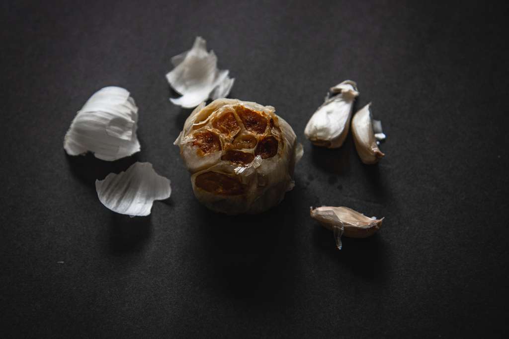 a bulb of roast garlic with some garlic cloves and peel around it