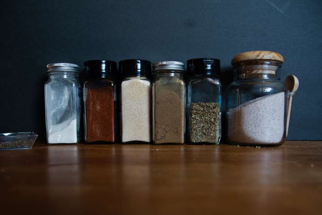 jars/bottles of different spices lined up.