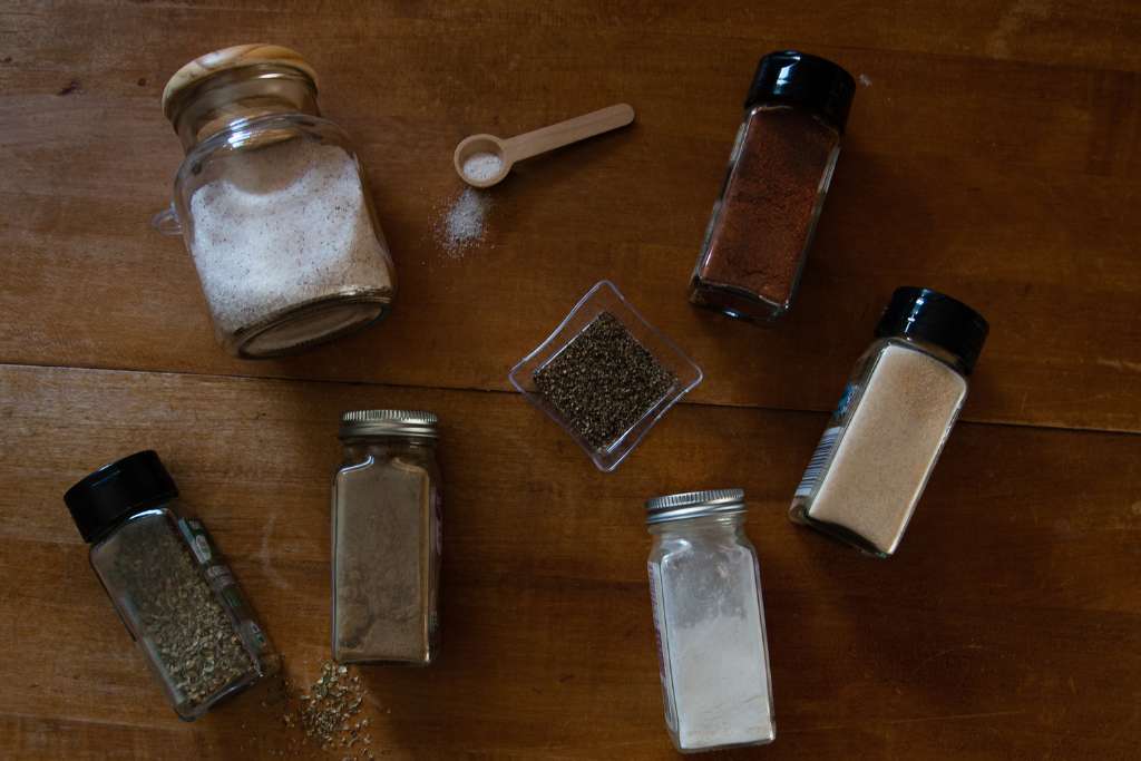 different spice bottles laying out on a table