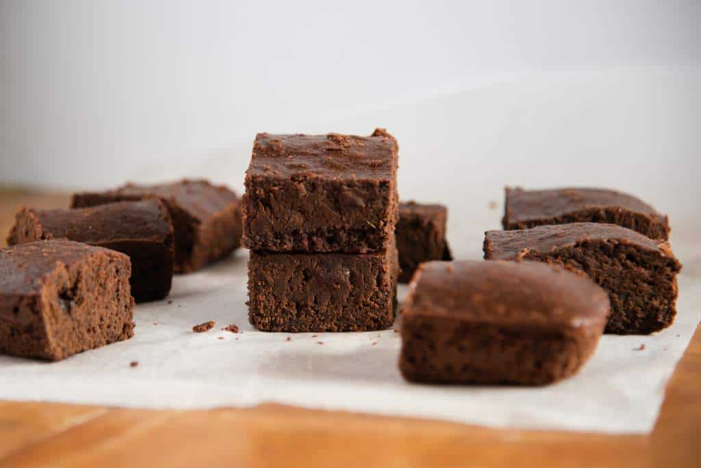 brownies spared out on a piece of parchment paper, there are two in the center stack on top of each other