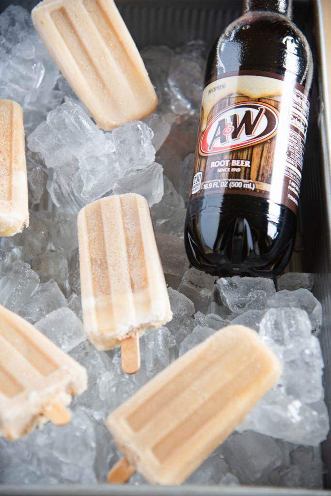 a pan full of ice with five cream bars and a bottle of A&W root beer in it 