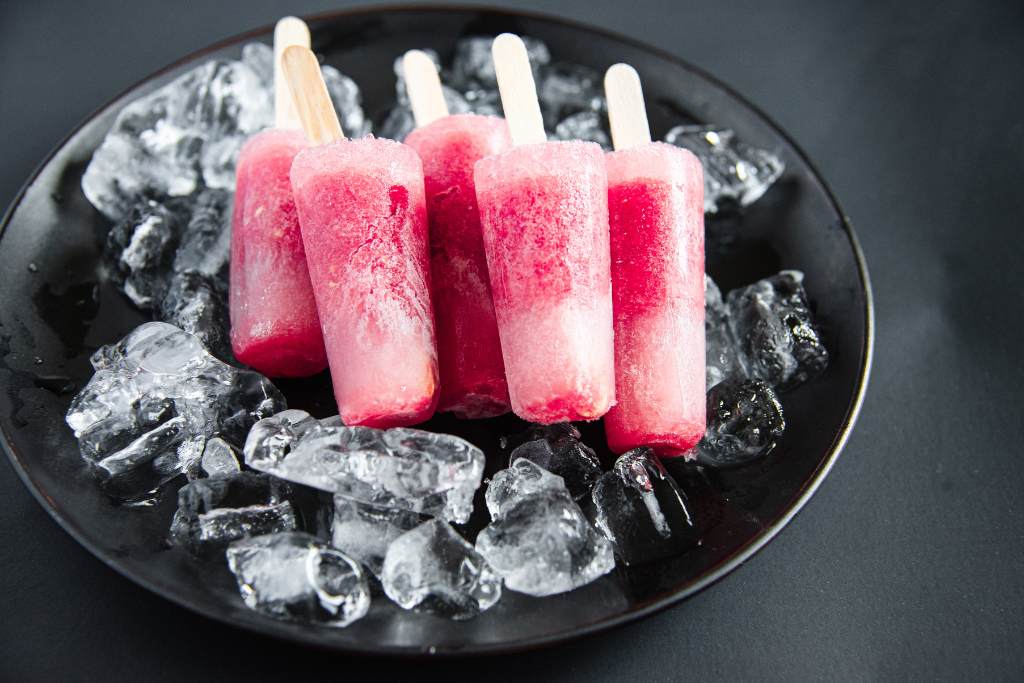 5 round popsicles lined up against each other on a plate of ice 