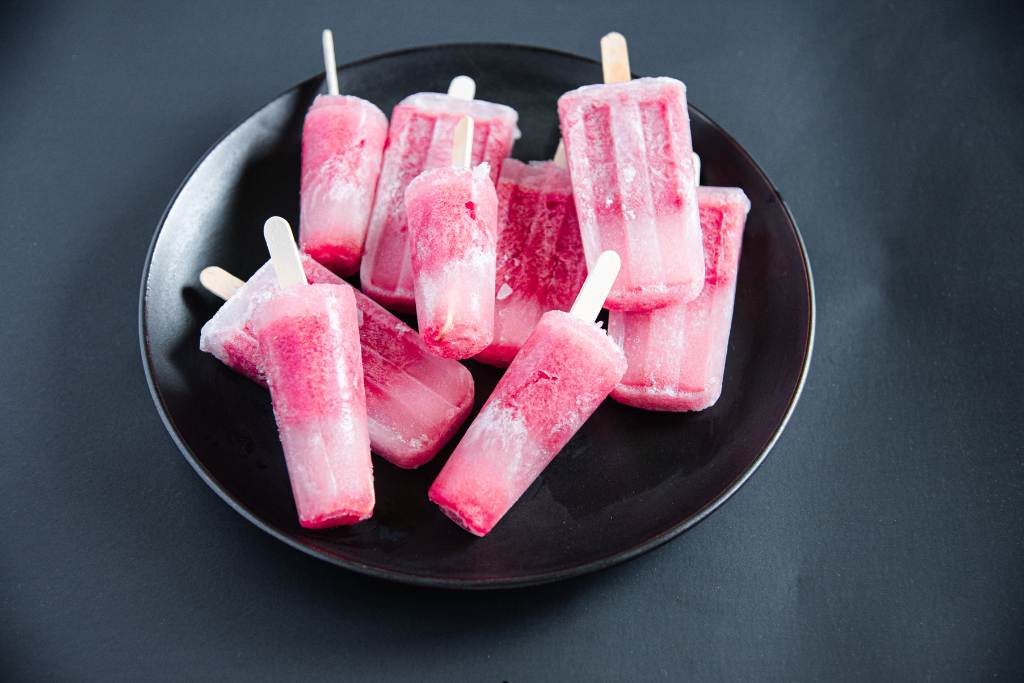 a bunch of popsicles stacked on up of each other on a round black plate