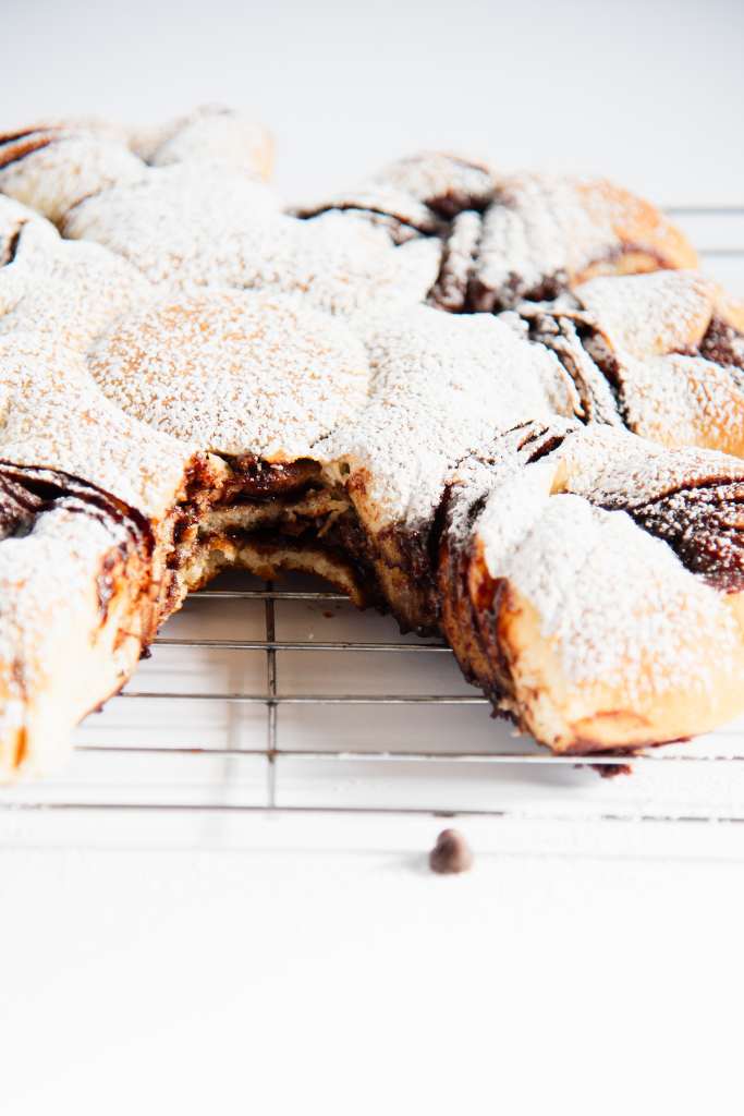 a star bread with 2 pieces taken out of it, so you can see the layers of bread and chocolate 