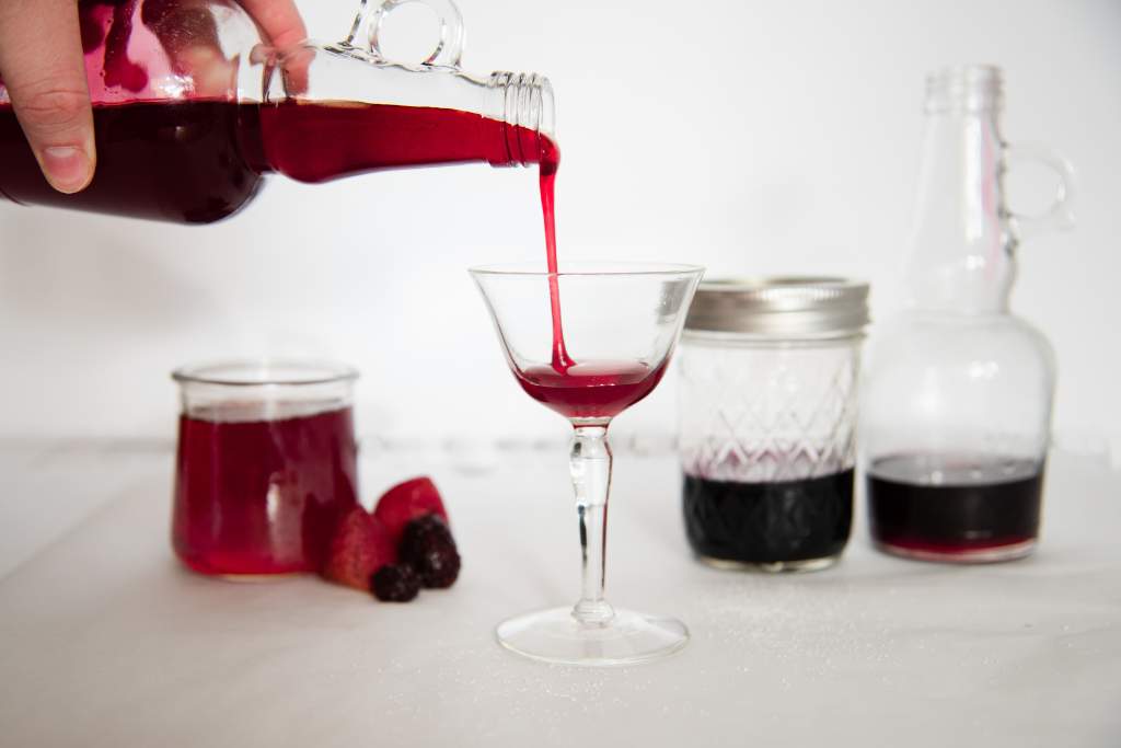 raspberry syrup being poured into a glass