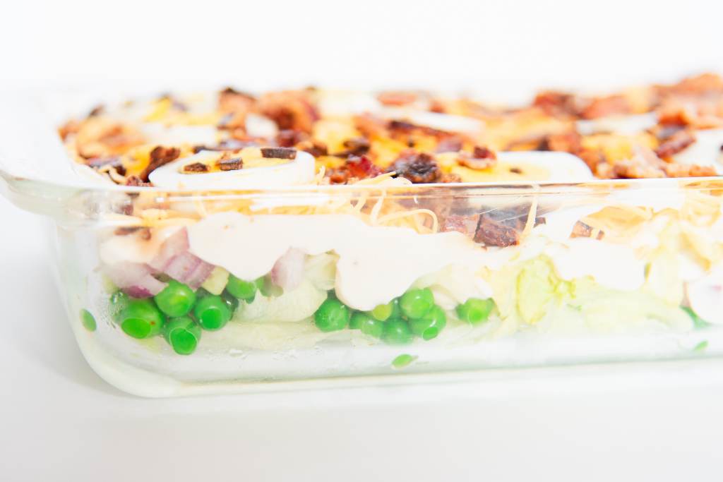 a glass cake pan of seven layer salad