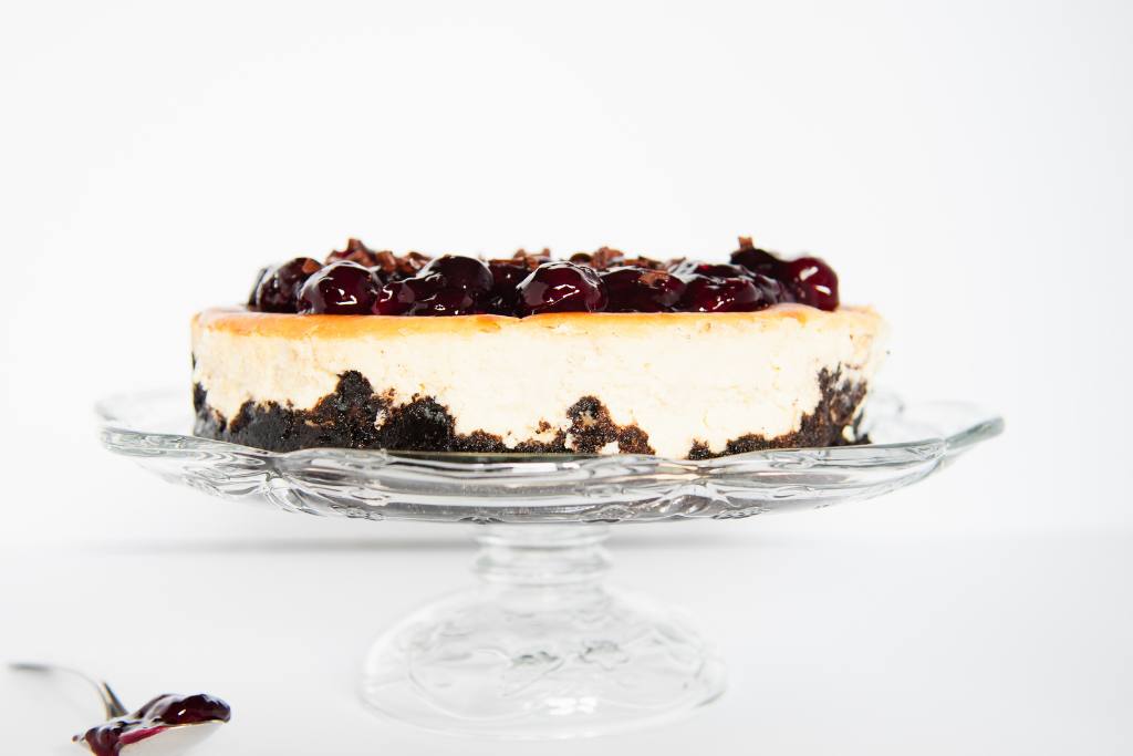 the side of a  finished cheesecake on a cake stand, 