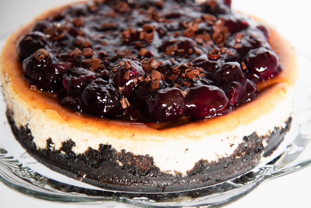 a cheesecake on a glass cake stand