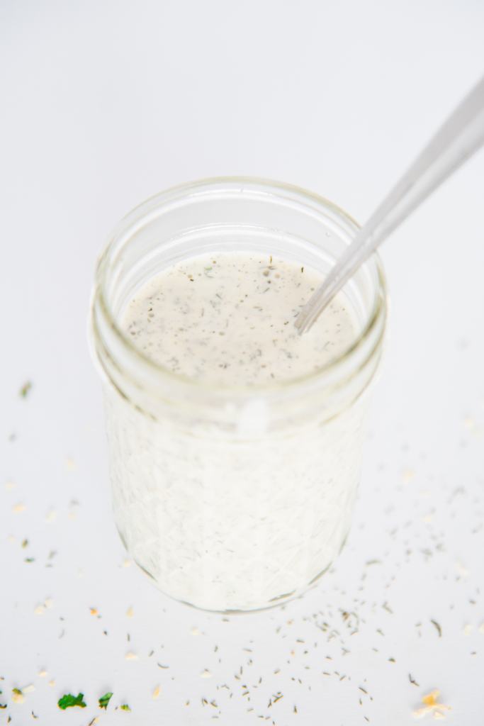 a jar of homemade ranch dressing with a spoon in it