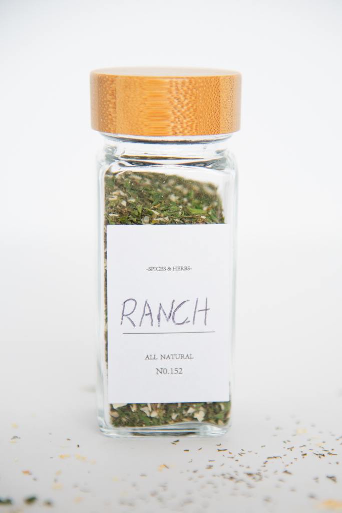 a glass spice bottle of ranch seasoning mix, with a label that says ranch  