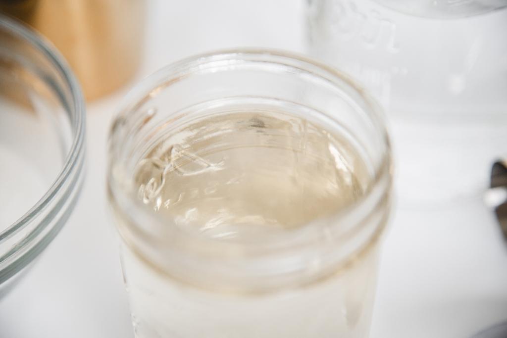 a close up of simple syrup in a small jar