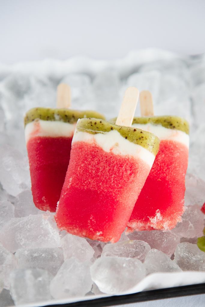 a close up of three popsicles on a tray on ice