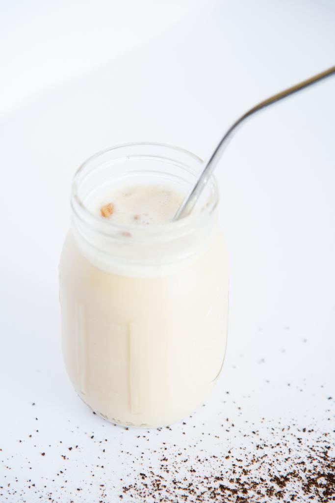 a jar of iced coffee with a metal straw in it 