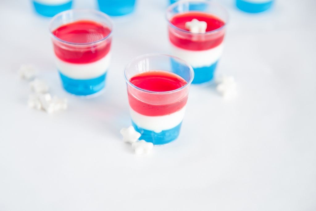 a close up of a jello shot with two more shots behind it, one of which has a white star on top of it 