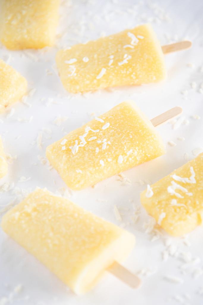 pina colada popsicles with coconut flakes on them