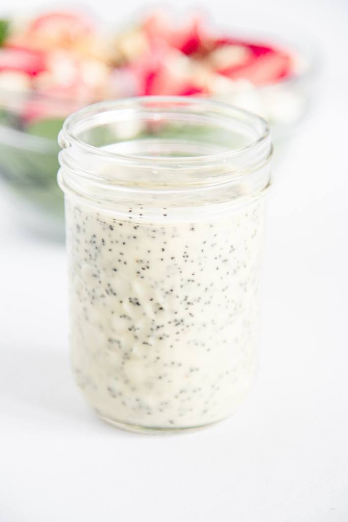 a close up of a jar of poppy seed dressing 