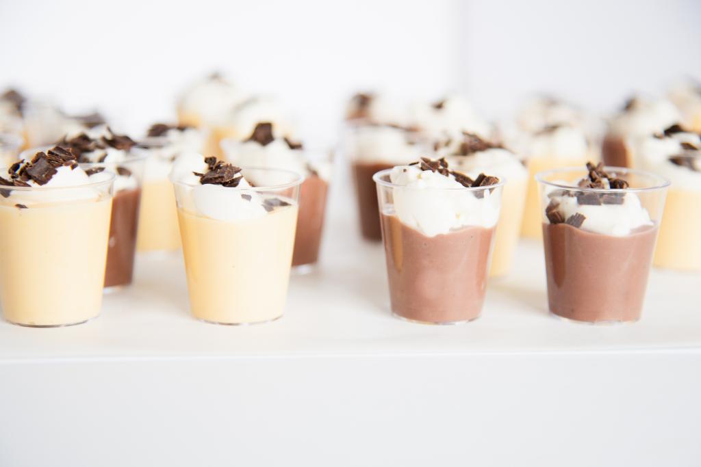 two vanilla pudding shots and two chocolate puddings shots in a line