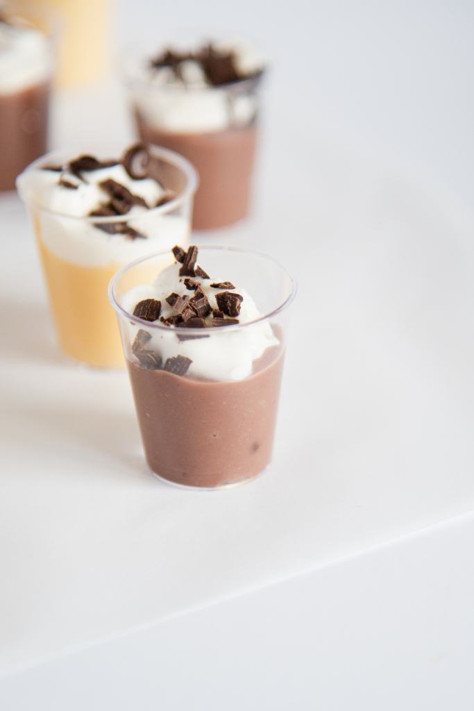 a close up of a chocolate pudding shot with a vanilla shot behind it