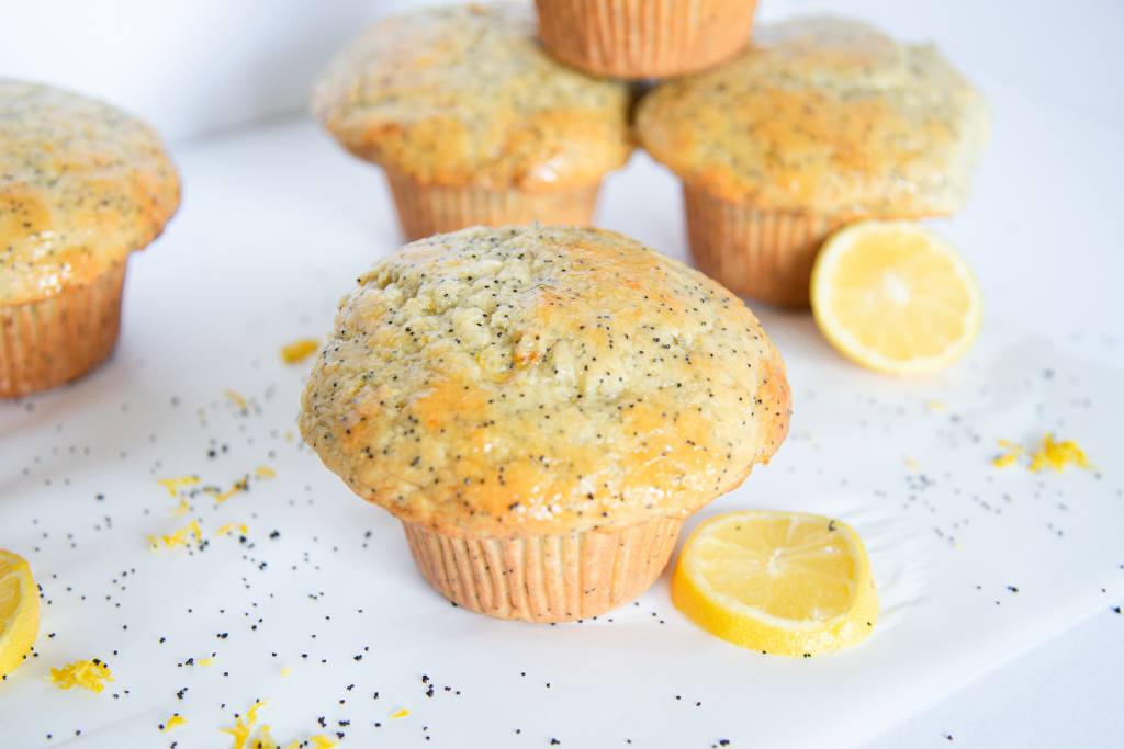 lemon poppy seed muffins with poppy seeds and lemon slices around them