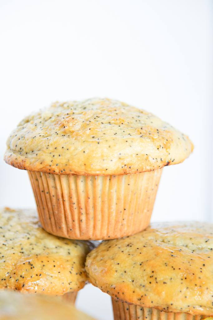 a lemon poppy seed muffin, stacked on two other muffins