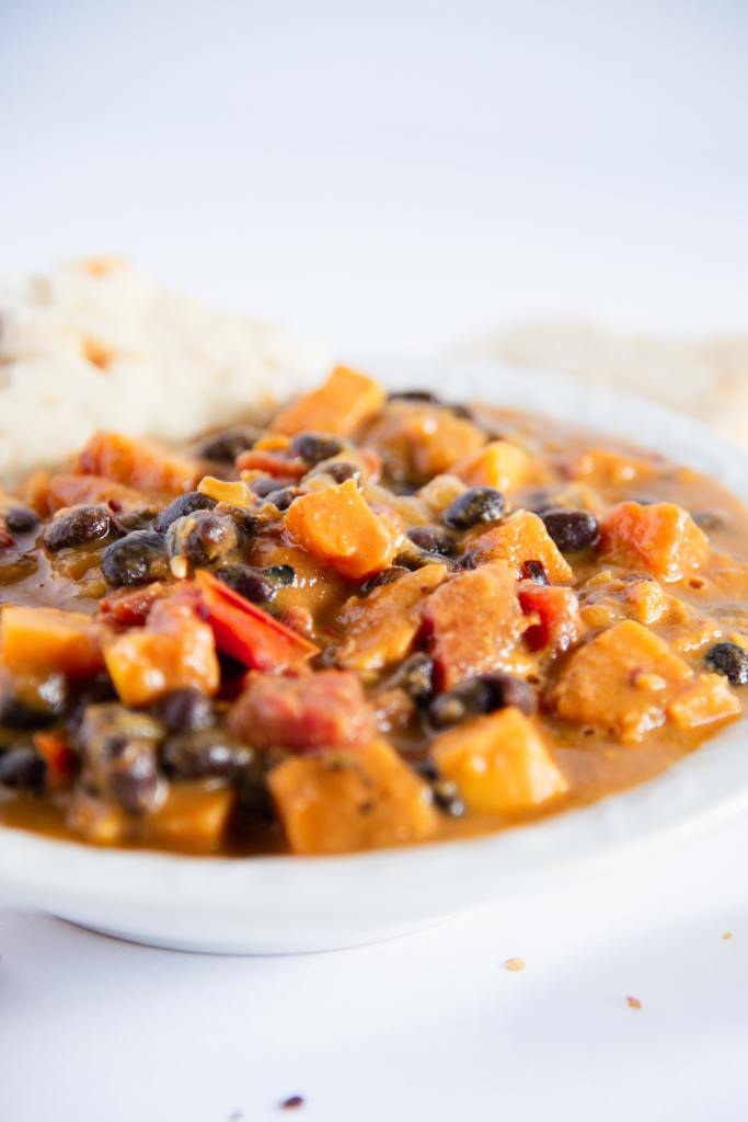 a close up of a bowl of black bean sweet potato curry 