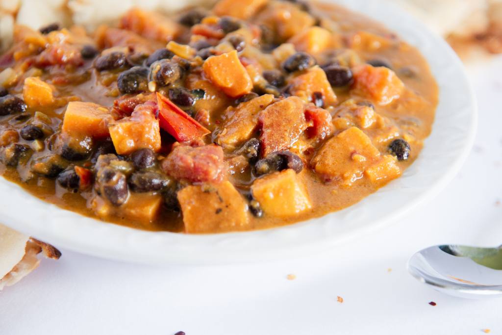 a close up of a bowl of curry, you can see part of a spoon next to it 