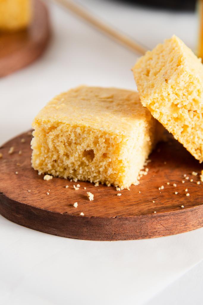 a close up of cornbread with another piece of cornbread set on top of it