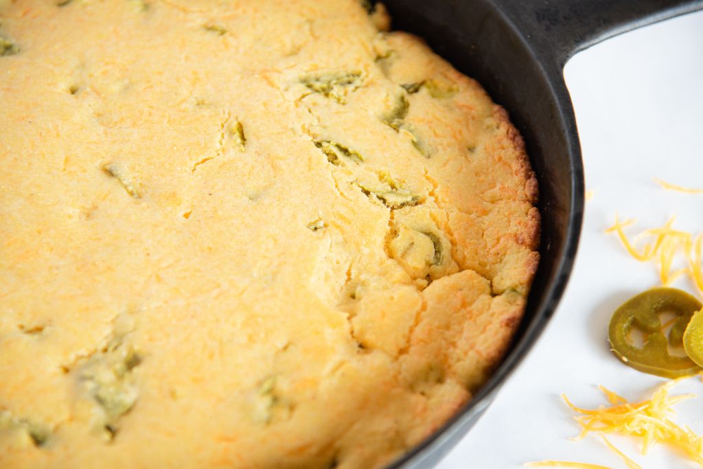 a close up of uncut cornbread in a cast iron skillet