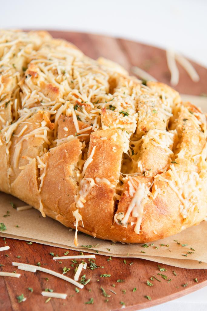 a close up of a loaf of cheesy bread with cheesy melted on top