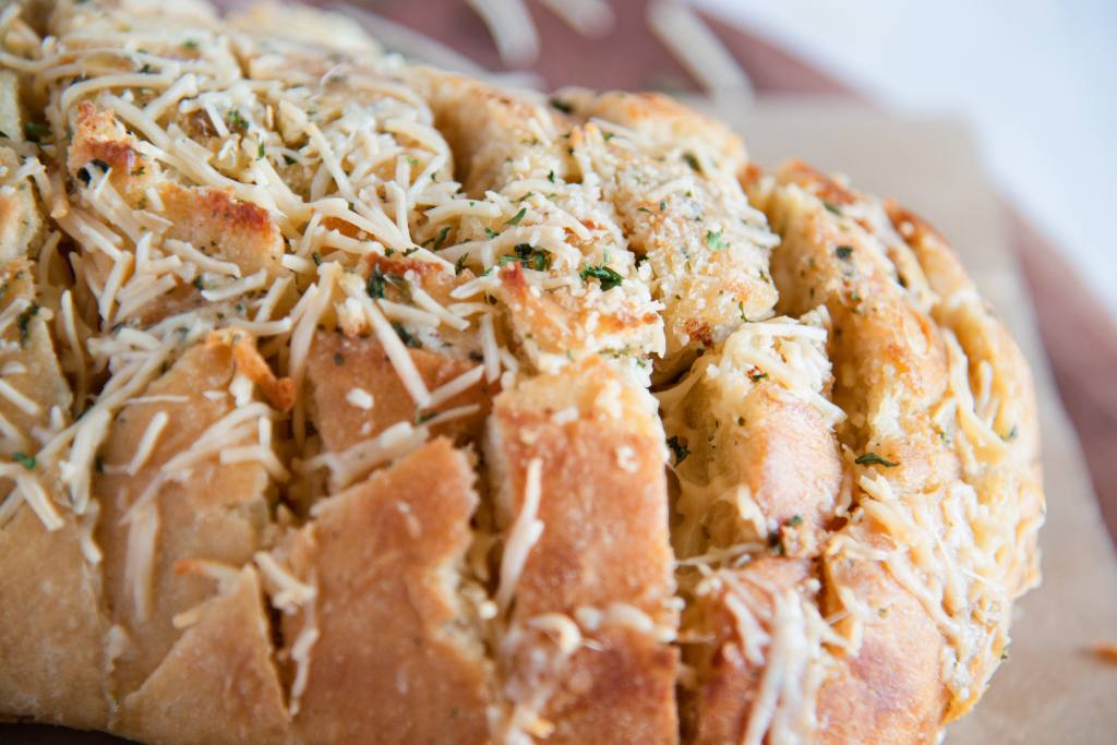 a very close up of the top of loaf of cheesy bread