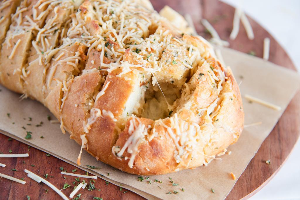 a loaf of cheesy bread with a piece taken out