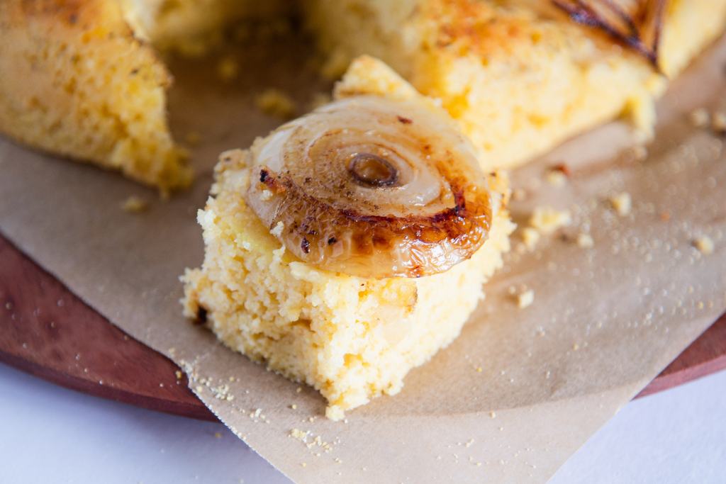 a close up of a piece of cornbread with caramelized onion on top