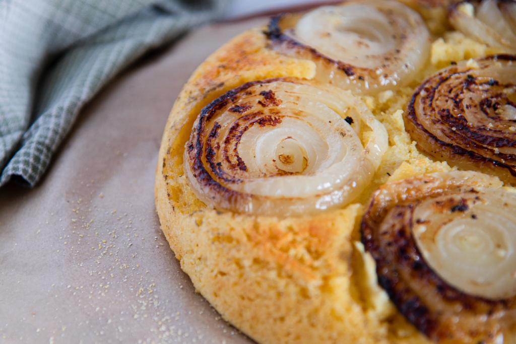 a close up of an upside down cornbread with onions on top