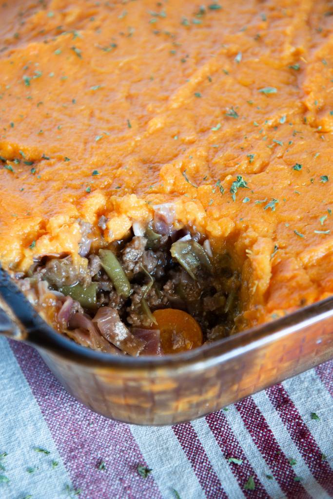 a pan of shepherd's pie with a scoop taken out of it