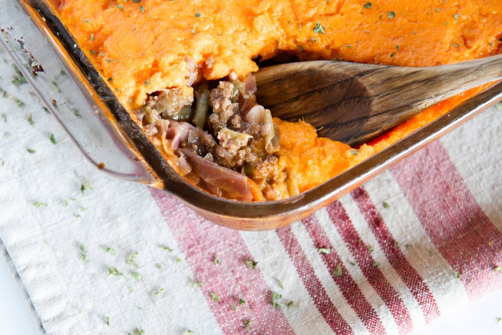 a spoonful of shepherd's pie being taken out of the pan