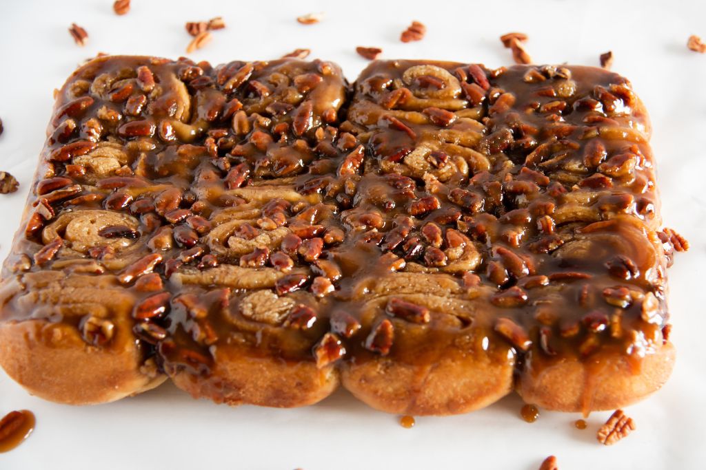 a sheet of pecan stick buns with chopped pecans around it