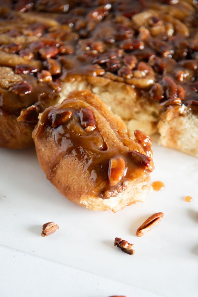 a pecan sticky bun pulled away from the rest of the sticky buns