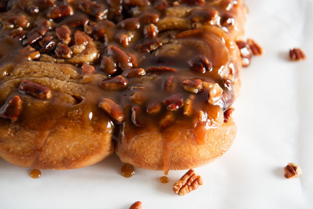 a close up of sticky buns, with caramel dripping down them