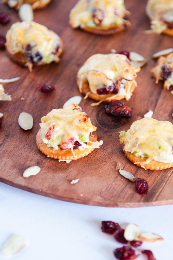 a close up of a few chicken salad bites on a wooden tray