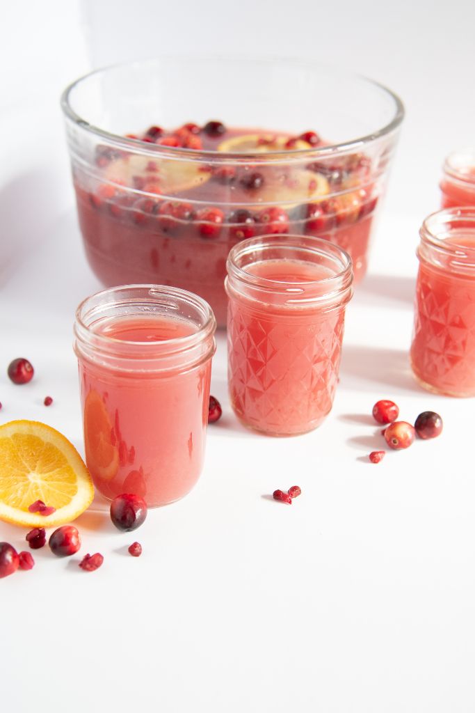 four glasses of lunch in front of a bowl of punch