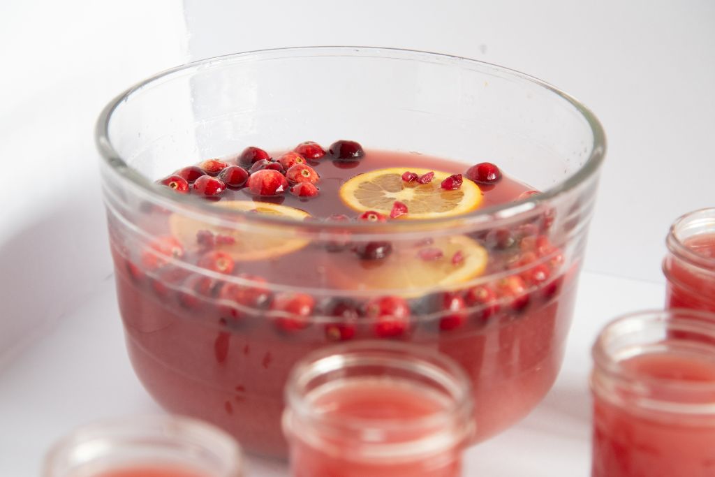 a bowl of punch with four cups in front of it